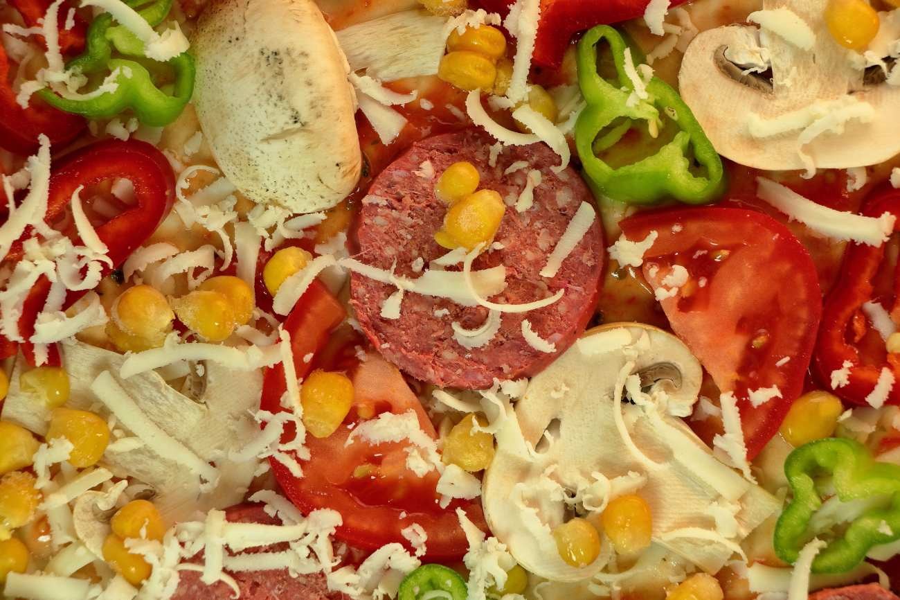 Pizza con salame, funghi, mais e peperoni