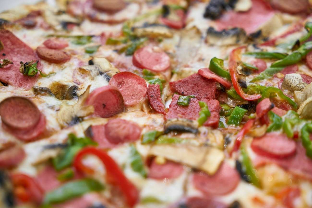 Pizza con salsiccia, funghi e peperoni